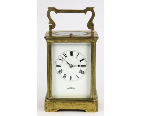 A brass carriage clock, the white enamel dial with Roman numeral chapter ring, signed Mann, Gloucester, twin train brass move