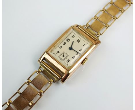 A Gentleman's 9ct gold wristwatch, the rectangular white dial with black Arabic numerals and subsidiary seconds dial, manual 