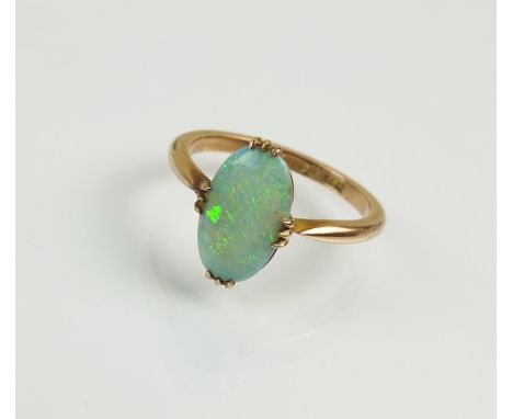 A 9ct gold single stone opal ring, the oval opal claw set in yellow gold, ring size N, weight 2.8g