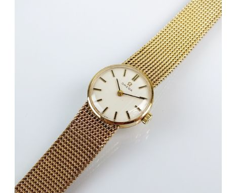 A Lady's 9ct gold Omega bracelet watch, the circular silvered dial with batons, manual wind, the 9ct gold textured tapered br