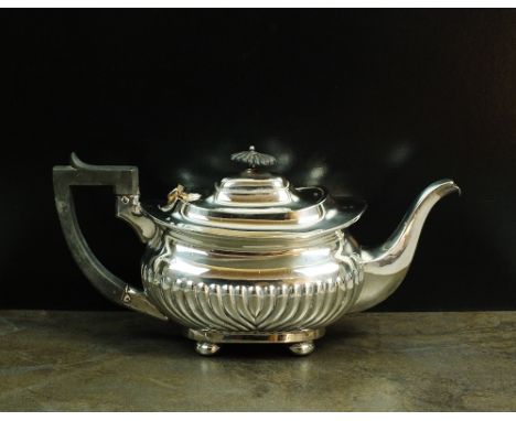 A Victorian silver teapot, JG, London 1898, of oval half reeded form with ebonised handle and finial, raised on four compress