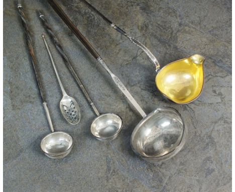 An 18th century shell back mote spoon, marks indistinct, 13.5cm long, together with four silver toddy ladles, each with turne