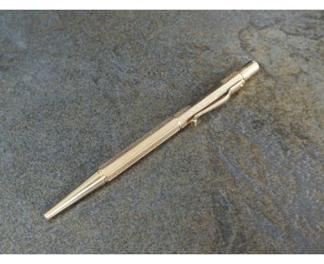 A 9ct gold retractable pencil, E Baker & Son, Birmingham, of hexagonal engine turned form, 11cm long, weight 19g