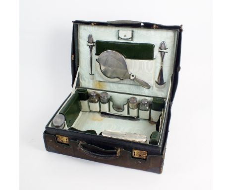 A cased travelling silver mounted vanity set, London and Birmingham, comprising; five silver topped jars/bottles, a silver ba