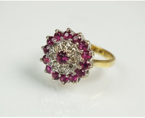 A ruby and diamond cluster ring, designed as a central raised round mixed cut ruby claw set within an inner border of eight d