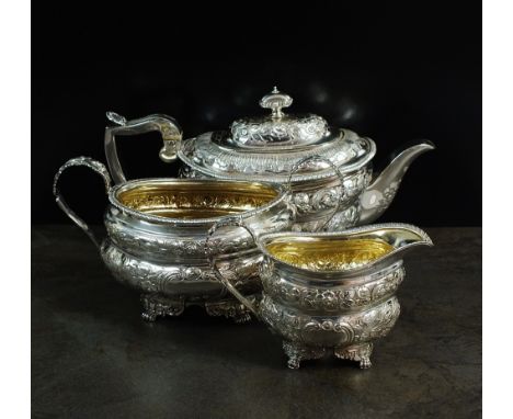 A matched three piece silver tea service, each piece of oval form with embossed floral scroll decoration, comprising; a teapo