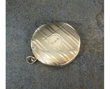 A Goldsmiths and Silversmiths 9ct gold circular vesta case, with reeded engine turned decoration, engraved to central cartouc