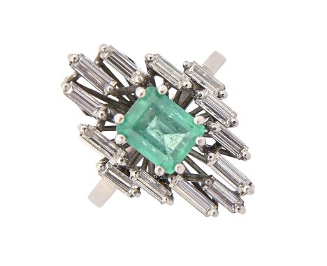 An emerald and diamond ring, the step cut emerald 5 x 6mm, in asymmetrical surround of baguette diamonds, in white gold, indi