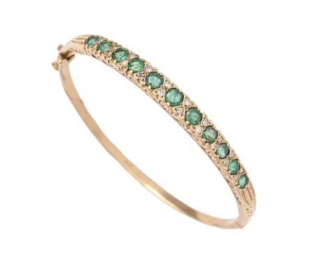 An emerald and diamond bangle, in 9ct gold, 56mm (internal), London 1989, 12.8g  Several of the emeralds slightly scratched /