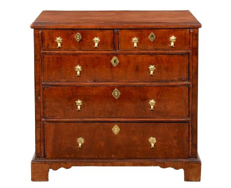A Queen Anne walnut and oak chest of drawers, with brass axe head handles, on bracket feet, 87cm h; 51 x 89cm Feet and handle