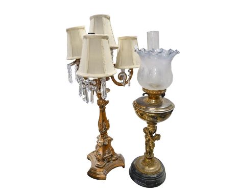 A gilt-brass and glass figural oil lamp, c. 1900, 74cm h, a four-light table lamp, 20th c, triform base, 80cm h, (2)  The oil