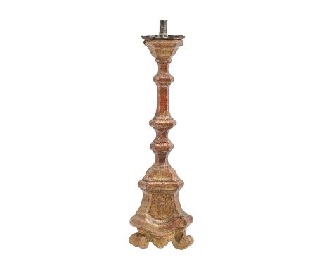 An Italian or Northern European giltwood altar candlestick, late 17th c, on three volute feet,&nbsp; sheet tin sconce, 61cm h