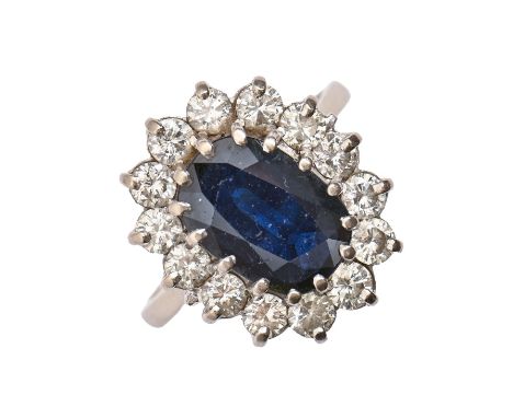 A sapphire and diamond ring, with 9 x 12mm oval sapphire in diamond surround, in 18ct white gold, 7.2g, size R  Good conditio