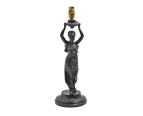 A French fin de siecle spelter figural lamp in the form of a young woman with arms upraised, c1900, on black glazed earthenwa