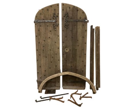 Pair of 19th century oak church doors, arched form with wrought iron rivets and scrolled strap hinges, together with architra
