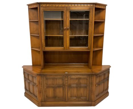 Ercol - 'Mural' sectional elm wall display unit, the central section fitted with two glazed doors over two panelled cupboards