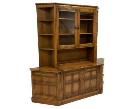 Ercol - 'Mural' sectional elm wall display unit, the central section fitted with two glazed doors over two panelled cupboards