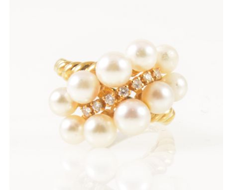 Mikimoto - an 18 carat yellow gold dress ring set with seven graduated small diamonds on the diagonal and surrounded by and t