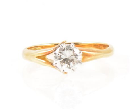 A diamond solitaire ring, the brilliant cut stone claw set in an 18 carat yellow and white gold shoulders mount with D shape 