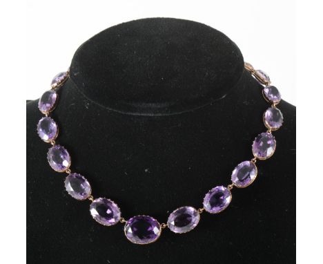 A Victorian riviere necklace, twenty-one oval faceted amethyst graduating in size from a centre stone of 19.5mm by 16.5mm to 