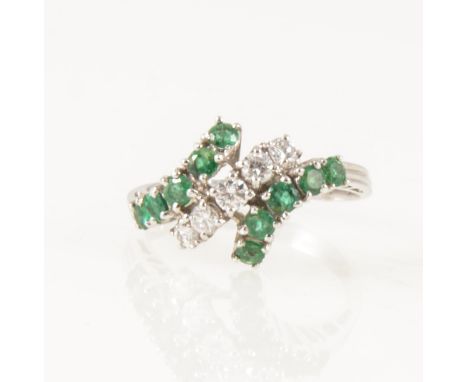 An emerald and diamond crossover ring, five graduated brilliant cut diamonds claw set on the diagonal with five emeralds set 