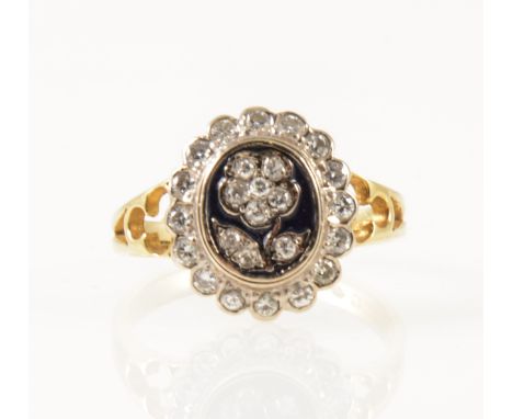 A diamond and enamel dress ring, the oval black enamel table set with an applied diamond set floral motif and surrounded by s