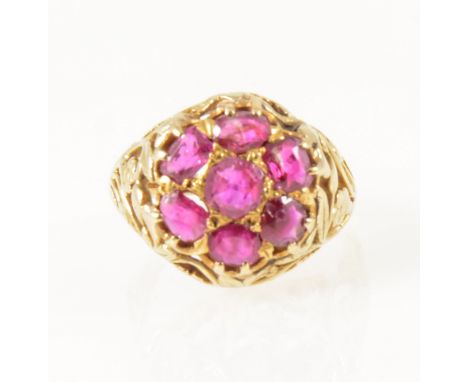 A vintage ruby cluster ring, the seven circular mixed cut rubies claw set as a cluster in an all yellow metal mount with entw