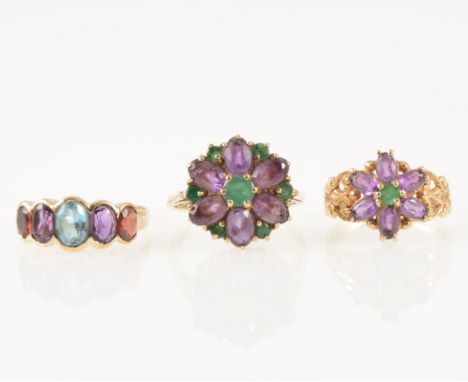 Three vintage amethyst dress rings, a 9 carat yellow gold ring set with a floral cluster of six amethyst and one small emeral