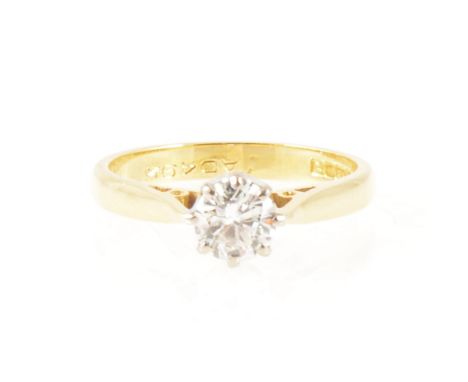 A diamond solitaire ring, the brilliant cut stone claw set in an 18 carat yellow and white gold single stone mount, hallmarke