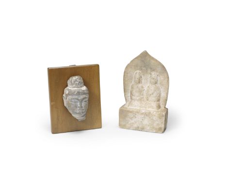 A marble carving of two disciples together with a limestone fragment of Buddha's headThe disciples, dated by inscription to A