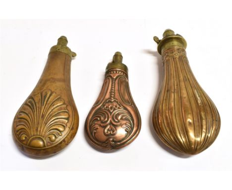 TWO BRASS POWDER FLASKS of stylized design and a small copper flask, all with brass mounts, the largest length 20cm (3)
