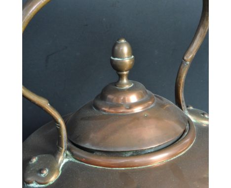 A large 19th century Victorian copper stove kettle having a hoop handle with an acorn finial atop the lid. Measures 33cm tall