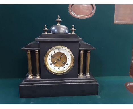 Victorian black slate mantle clock with brass column case, domed pediment with French striking movement.