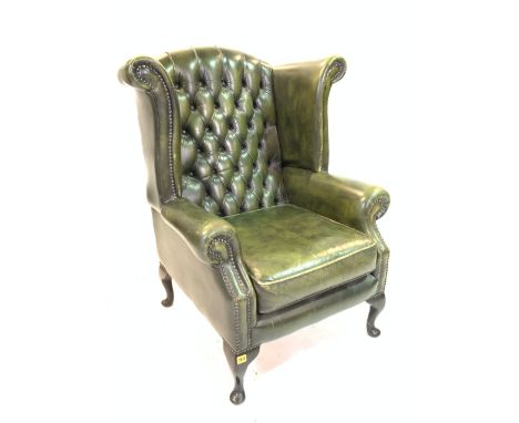 A VICTORIAN STYLE WINGBACK ARMCHAIRWith green leather button back upholstery, 80cm wide; 106cm high