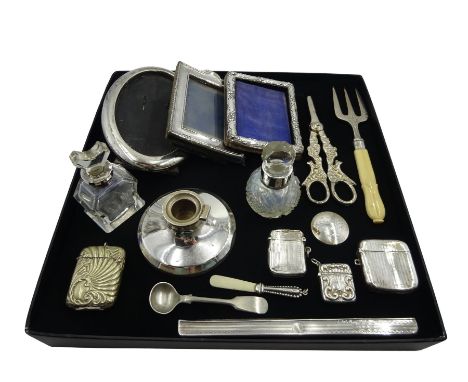 Three small silver photograph frames, two silver vesta cases, silver inkwell, two silver mounted glass bottles, all hallmarke