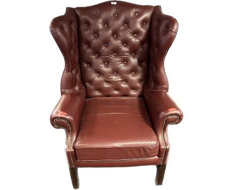 Ox blood leather button back Churchill chesterfield high back wing chair with brass nail head trim. 
