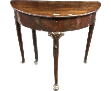 19th Century Mahogany card table, demilune surface opening to circular form raised on turned tapered legs ending in bun feet.