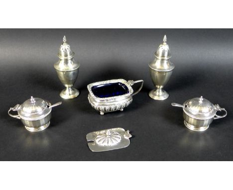 A group of five silver Victorian and Edwardian condiments, comprising a pair of Victorian urn shaped peppers, with spiral fin