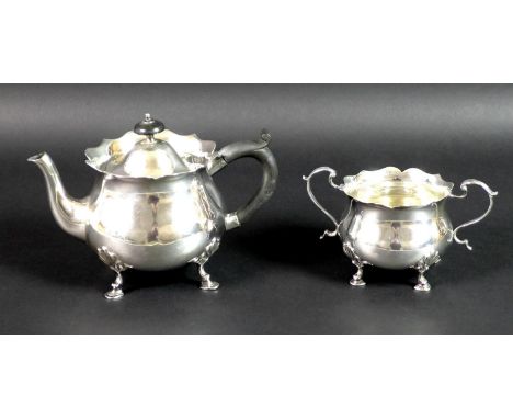 An Edward VII silver teapot and sugar bowl, of bombe form with scalloped rims, raised on four shell mounted pad feet, the tea