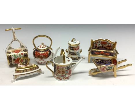 A set of seven Royal Crown derby Imari palette miniature models, comprising watering can, flat iron, garden bench, garden rol