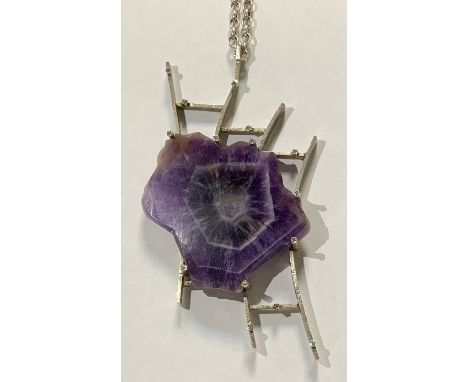 An unusual diamond and amethyst pendant necklace, irregular free form slice of rough polished amethyst mounted within a hand 
