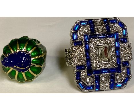 A base metal dress ring, green and blue enamel, surmounted with a frog, size L and another large base metal dress ring, size 