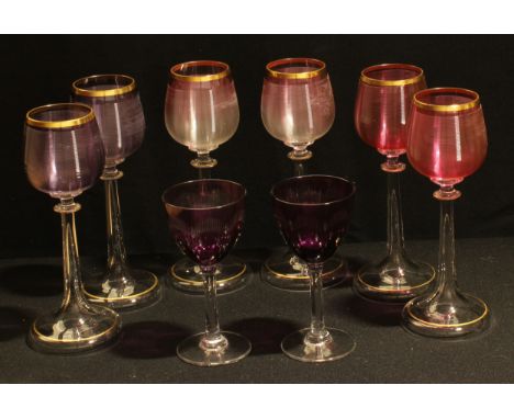 A set of six tulip shaped hock wine glasses, the ribbed bowls in shades of pink and amethyst, slender hollow tapering stems, 