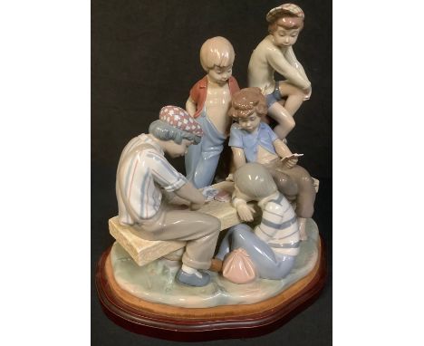 A large Lladro figure group, The Card Game, a group of boys playing a game of cards, stepped wooden plinth base, 35cm high ov