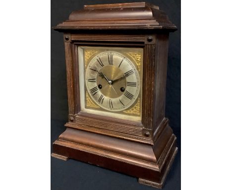 An oak mantel clock, silvered chapter ring with Roman numerals, twin winding holes, 14 day, striking on a bell, 36cm 