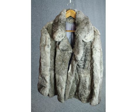 A vintage grey rabbit fur short winter coat with grey silk lining. The coat has a wide collar. 