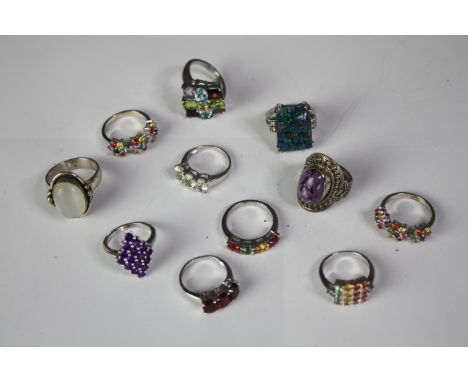 A collection of eleven silver gem-set rings of various designs. Set with peridot, aquamarine, Opal triplet mosaic, coloured s