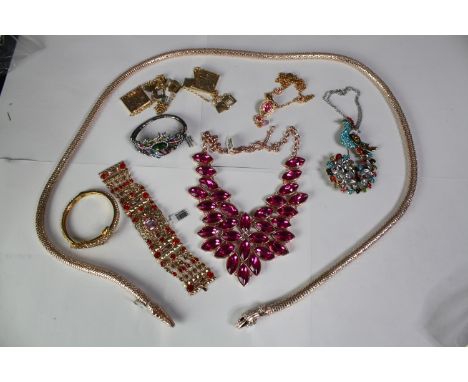 A collection of 20th century paste set jewellery, including a statement pink paste panel necklace, a peacock feather bangle, 