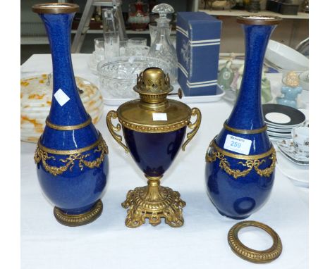 A matched garniture comprising a pair of porcelain powder blue baluster vases with ormolu garland mounts, and a similar table