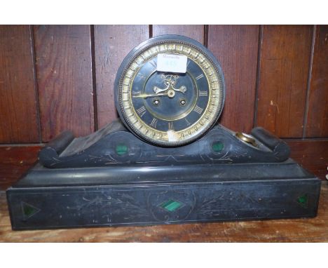 A 19th century French drum shaped black marble mantel clock with striking movement and visible escapement; an architectural m
